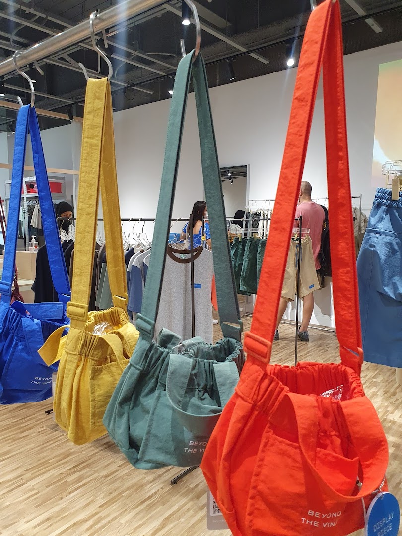 Colorful Beyond The Vines bags displayed on a rail inside the Funan store.