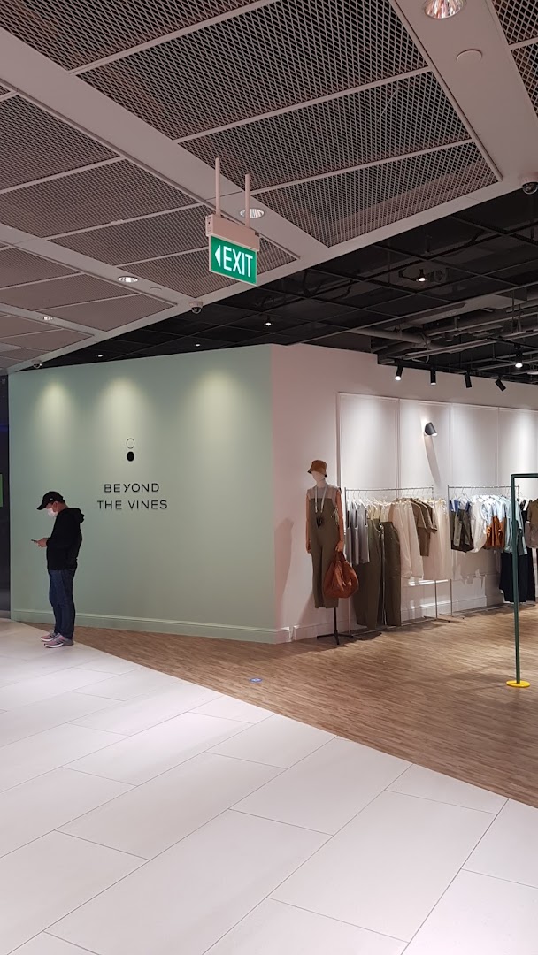 The entrance of Beyond The Vines Design Store with its minimalist logo and a customer browsing.