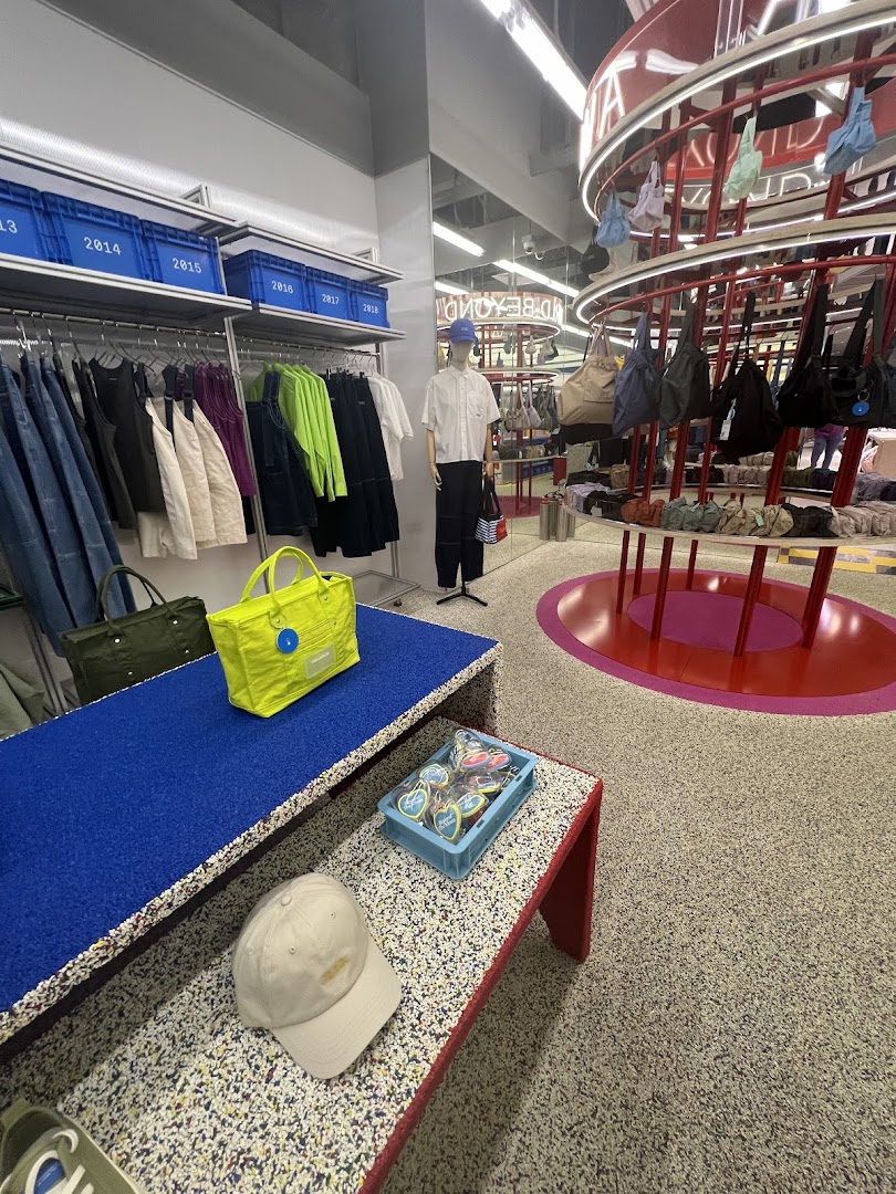 Interior view of Beyond The Vines Design Store, showcasing modern apparel, bags, and accessories on unique displays.