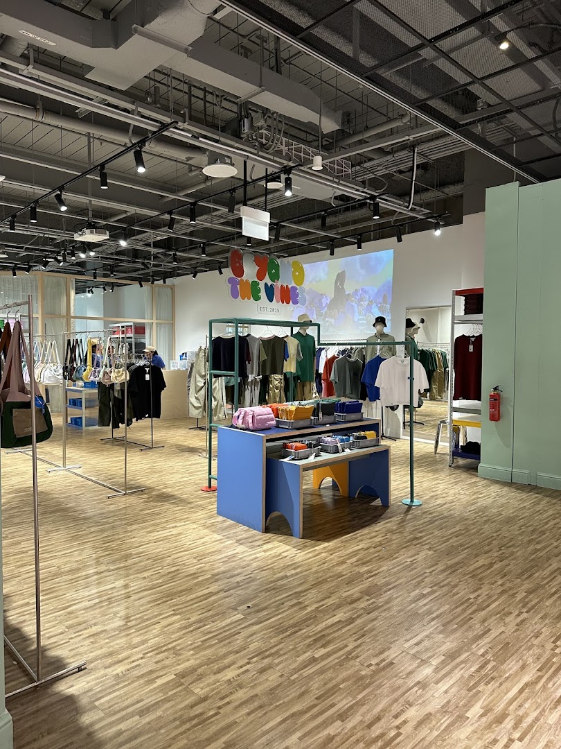 Interior view of Beyond The Vines Design Store, showcasing clothing, bags, and accessories on display.