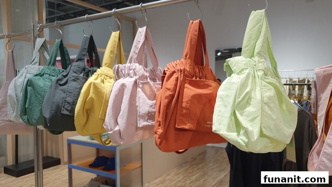 A vibrant display of colorful tote bags from Beyond The Vines hanging on a rail.