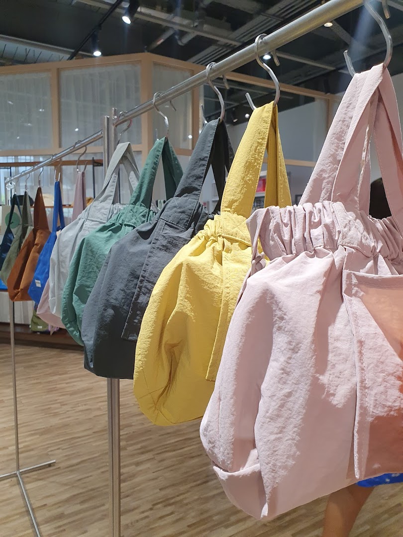 A vibrant display of colorful, stylish tote bags hanging on a rack inside the store.