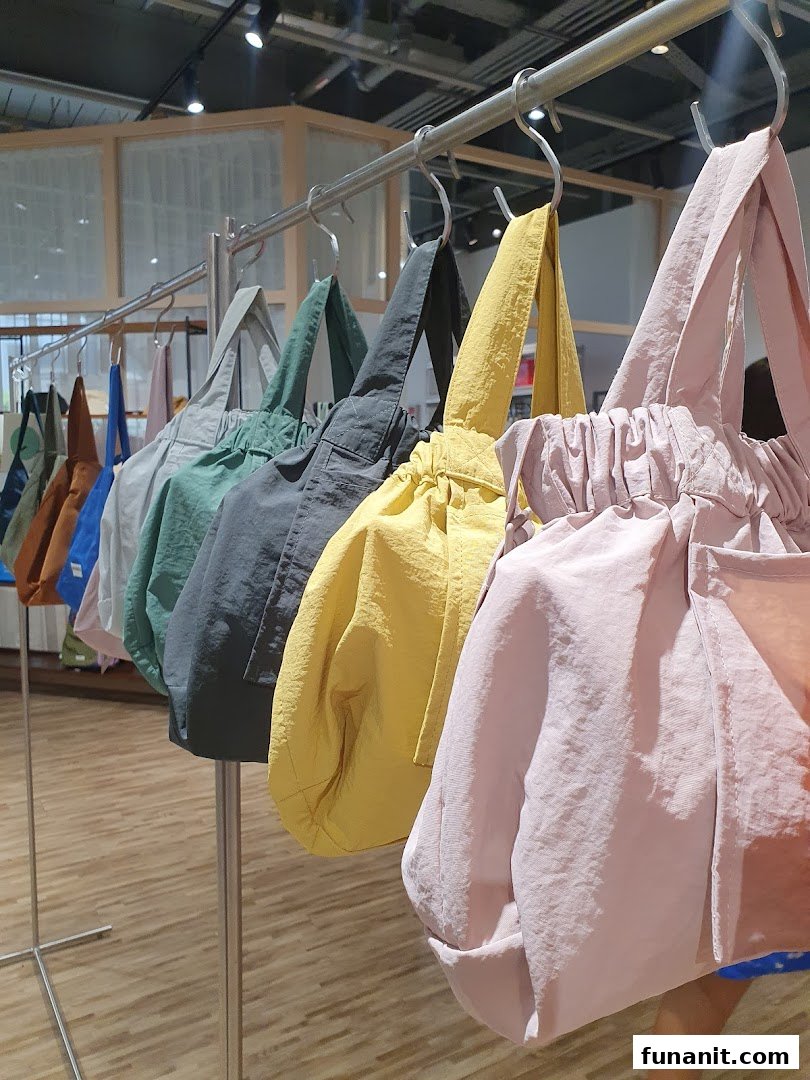 A vibrant display of colorful, stylish tote bags hanging on a rack inside the store.