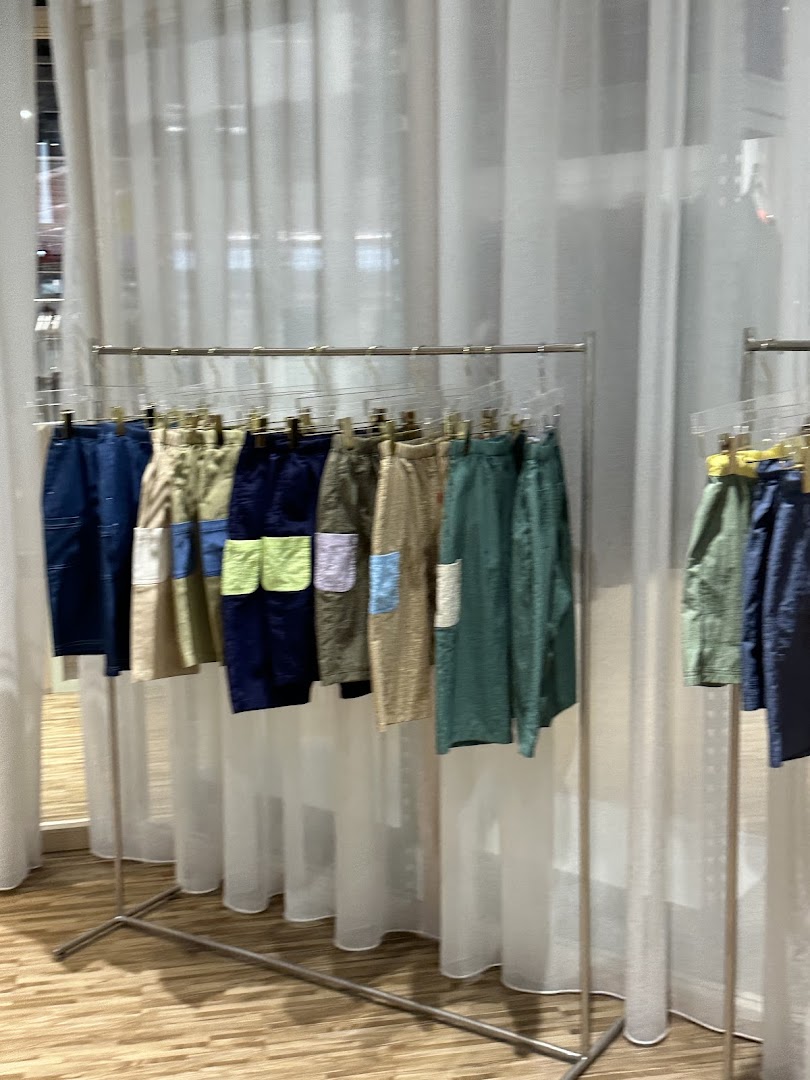 Colorful shorts and pants displayed on a clothing rack inside Beyond The Vines Design Store.