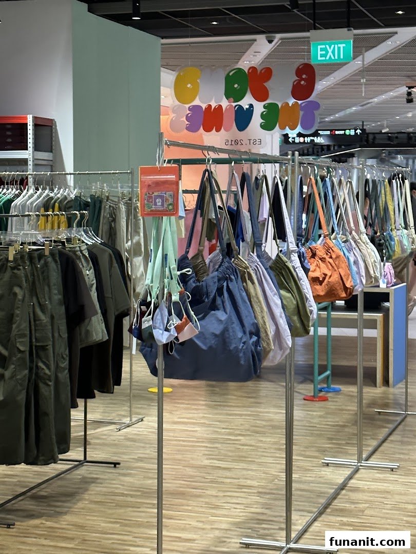 Interior view of Beyond The Vines Design Store, featuring clothing racks and a vibrant display of bags.