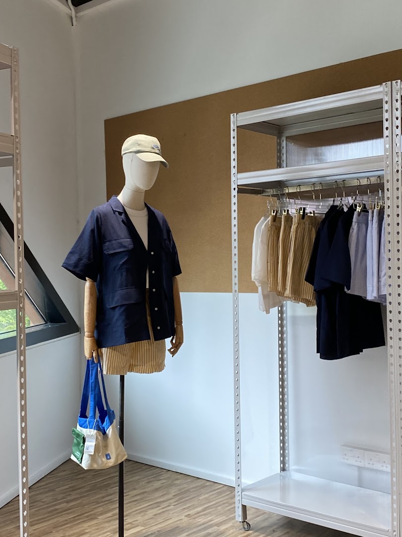 A mannequin displays apparel next to clothing racks inside Beyond The Vines Design Store.