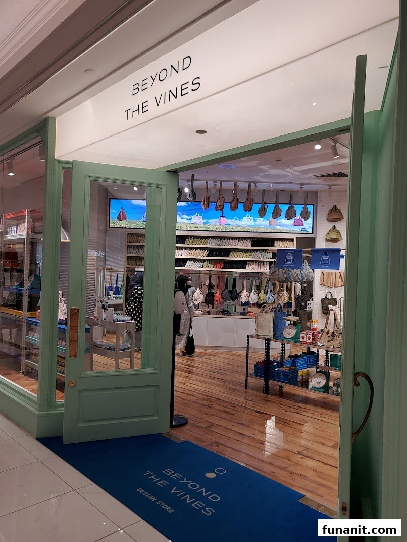 The inviting entrance of Beyond The Vines Design Store, featuring its signature green doors and a glimpse of its interior.