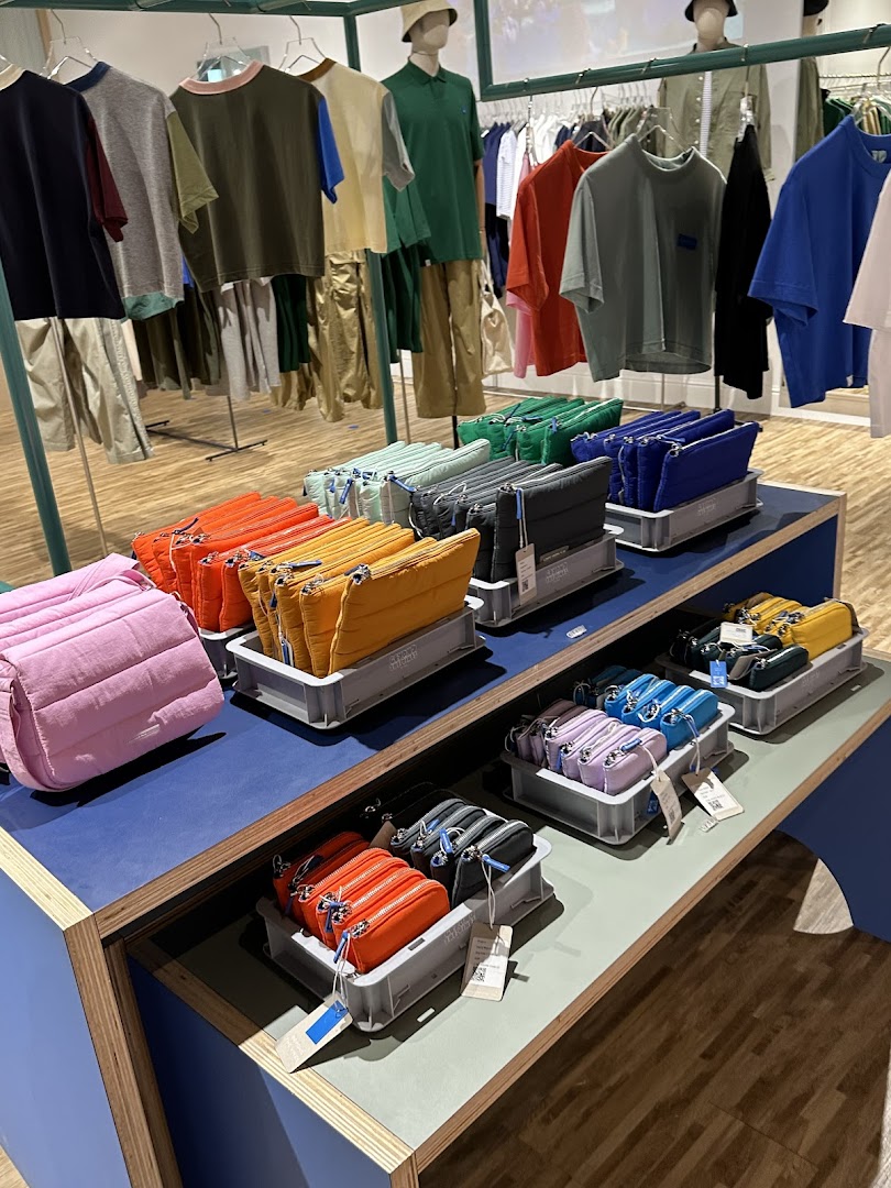 Vibrant display of colorful bags and casual apparel in a modern retail store.
