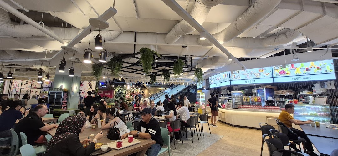 A lively interior view of Big Appetite, a bustling food court with diners enjoying meals.