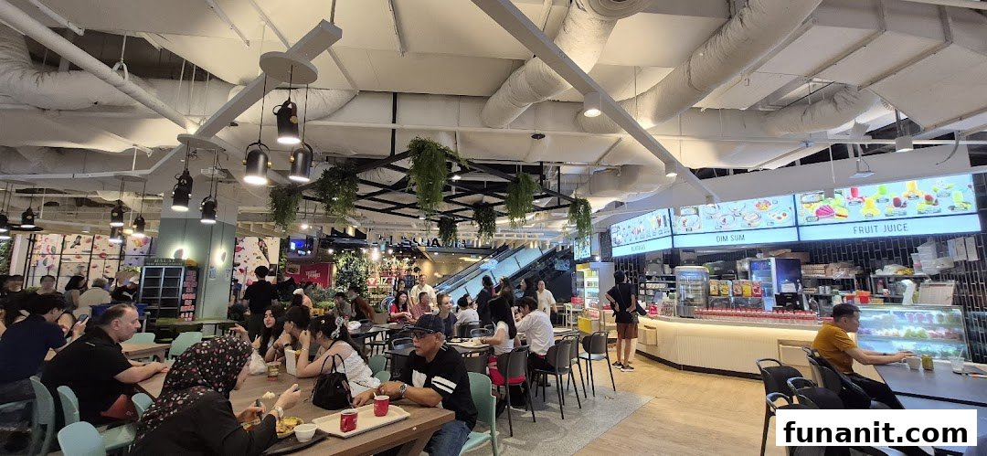 A lively interior view of Big Appetite, a bustling food court with diners enjoying meals.