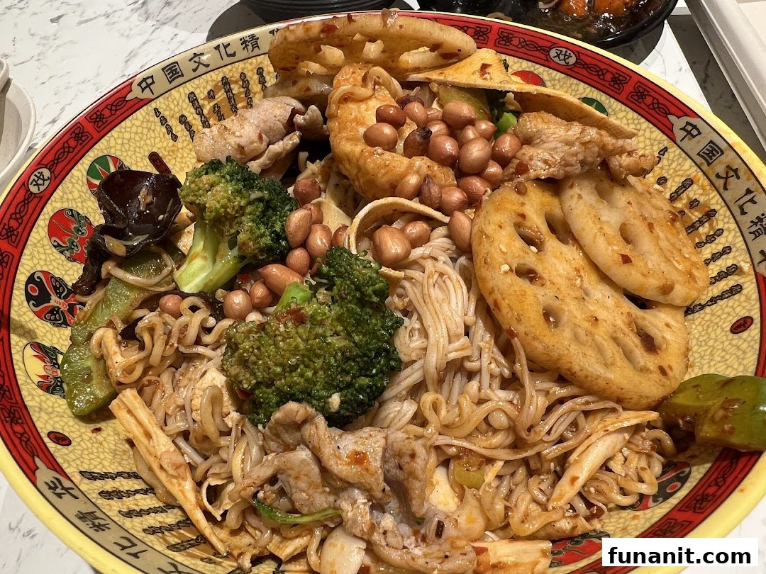A vibrant, large bowl of Chinese mala xiang guo with noodles, vegetables, and meat.