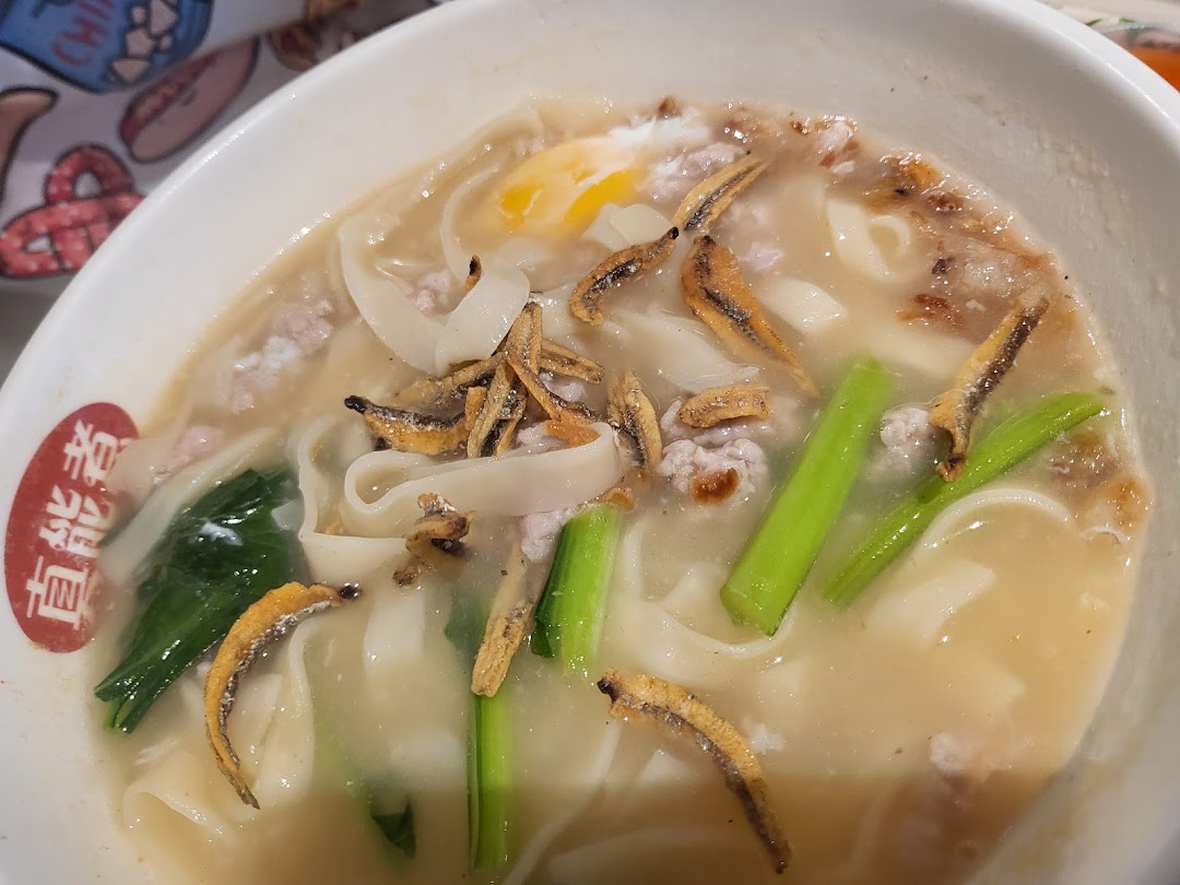 A hearty bowl of noodles with minced meat, crispy anchovies, vegetables, and a poached egg.