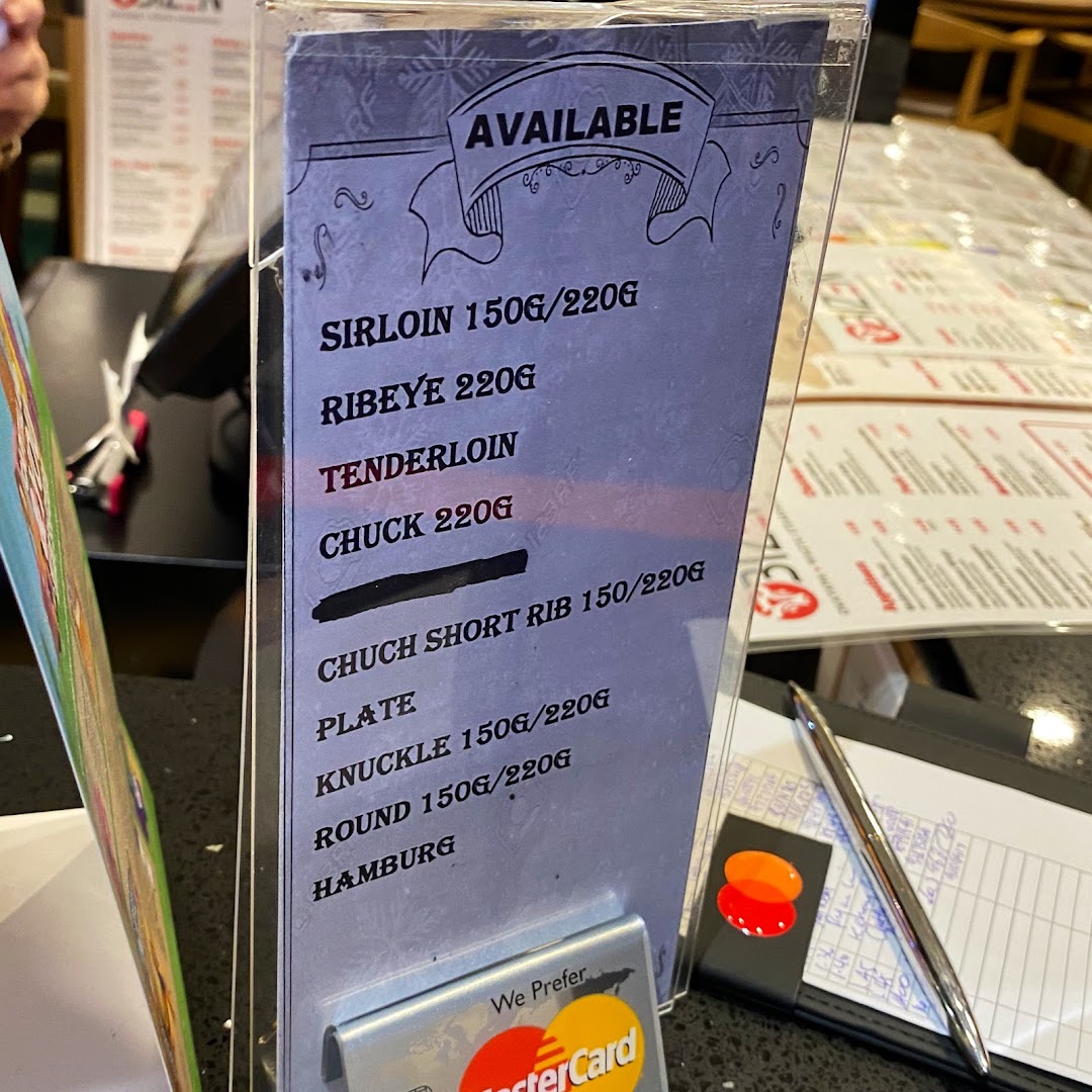 A close-up of a table-top menu displaying available wagyu steak cuts.