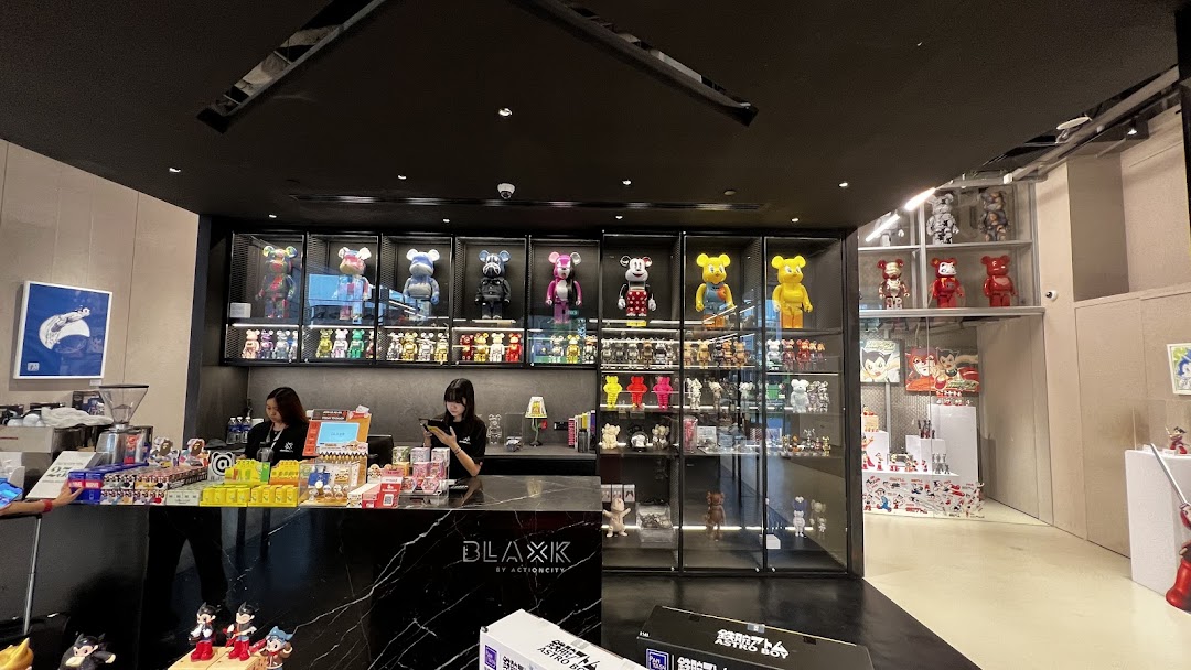 Interior view of BLAXK by ActionCity, showcasing collectible figures, merchandise, and a sleek counter.