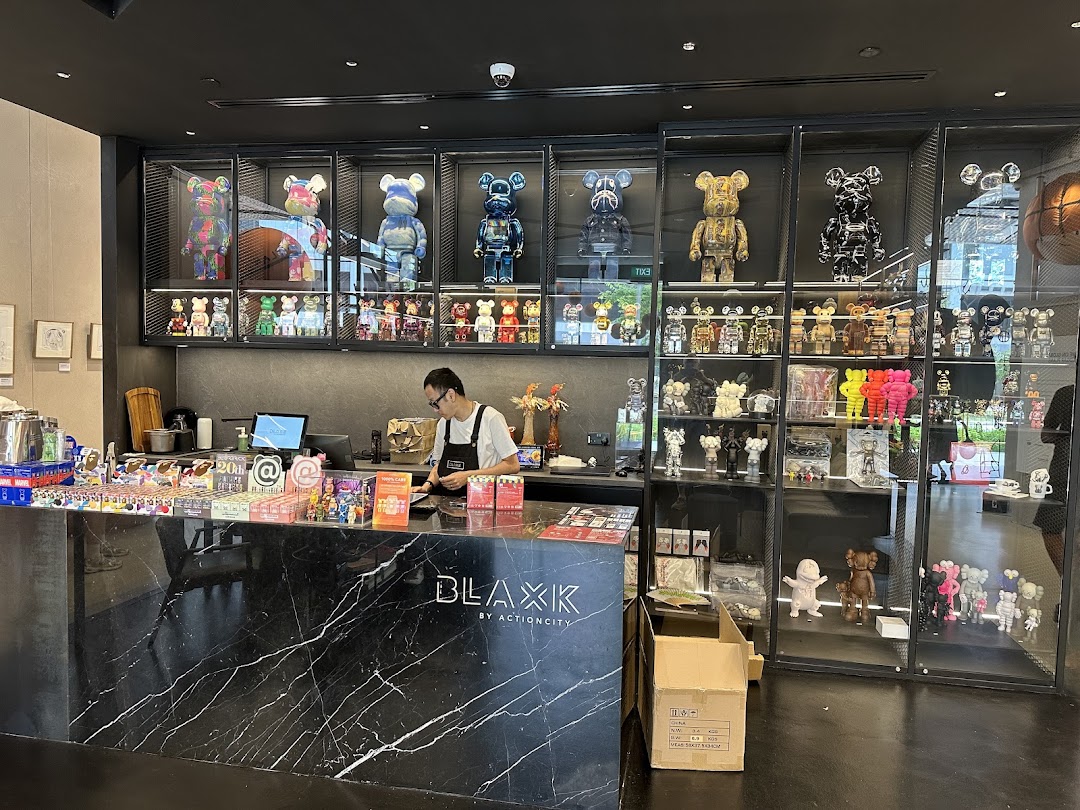 Interior view of BLAXK by ActionCity, featuring a counter, staff, and extensive displays of collectible art toys.