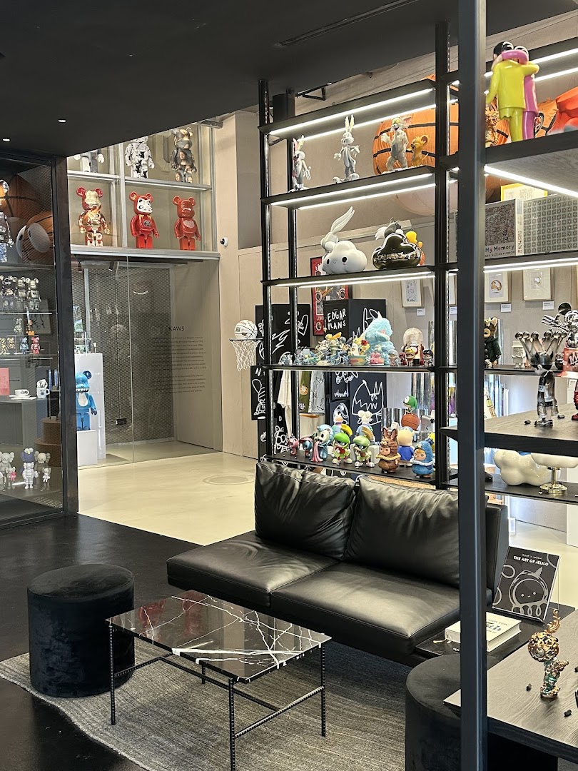 Interior view of BLAXK by ActionCity, showcasing a modern lounge area and shelves filled with unique art toys and collectibles.