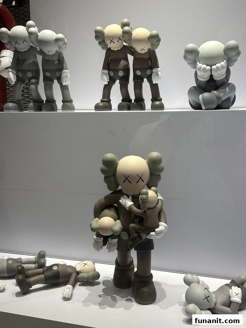 A display of various KAWS Companion art toy figures in different poses and colors on white shelves.