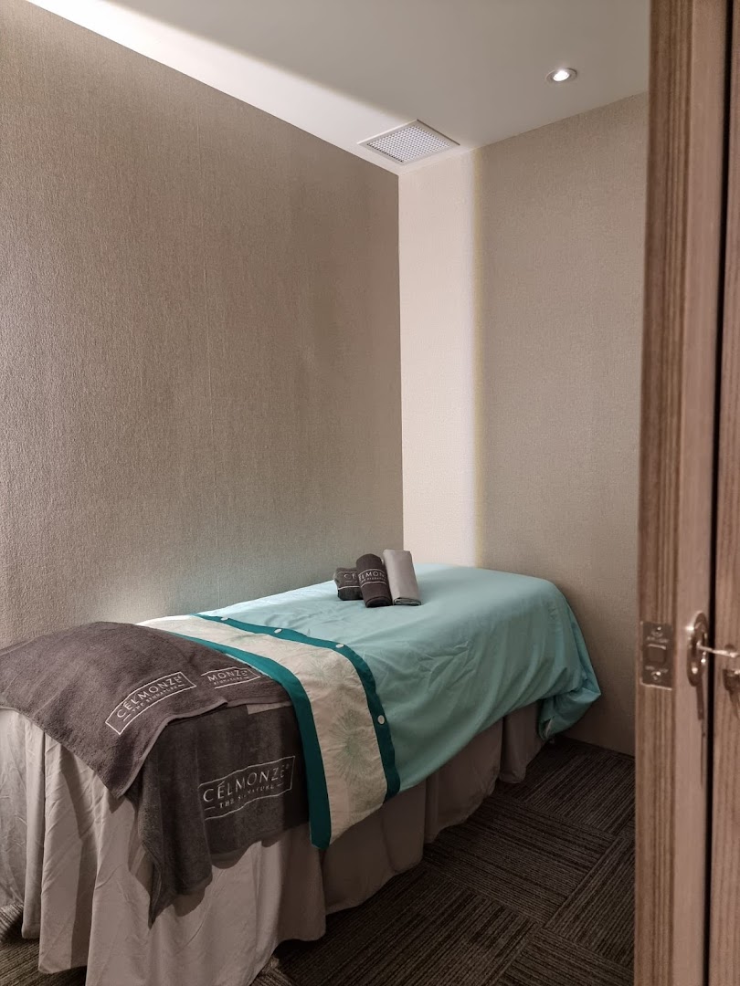 A serene treatment room at Celmonze Signature, featuring a comfortable bed and branded towels.