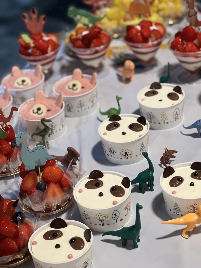 A delightful display of Châteraisé desserts, including cute panda and bear-themed treats, alongside fresh strawberry parfaits.