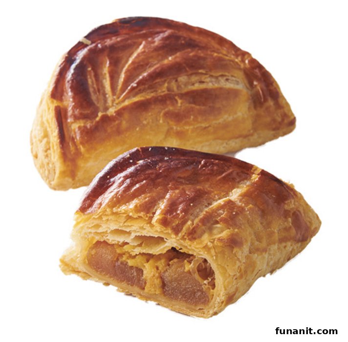 Golden-brown puff pastries, one cut open to reveal a delicious fruit filling.