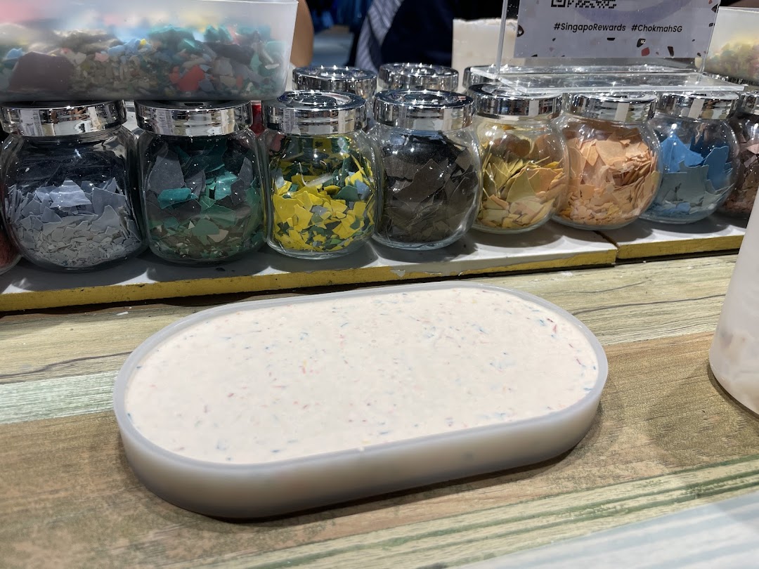 Jars of colorful flakes and a tray of white material, likely for custom product creation at Chokmah.