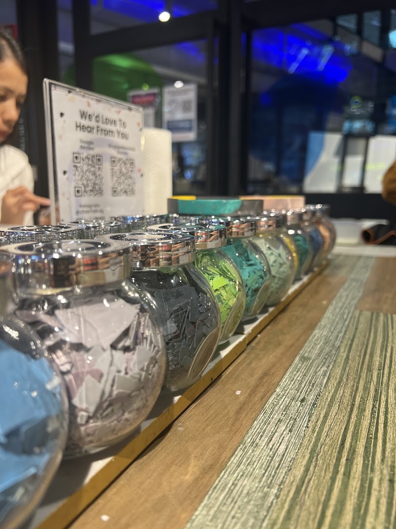 A vibrant display of colorful decorative jars on a wooden counter inside Chokmah.