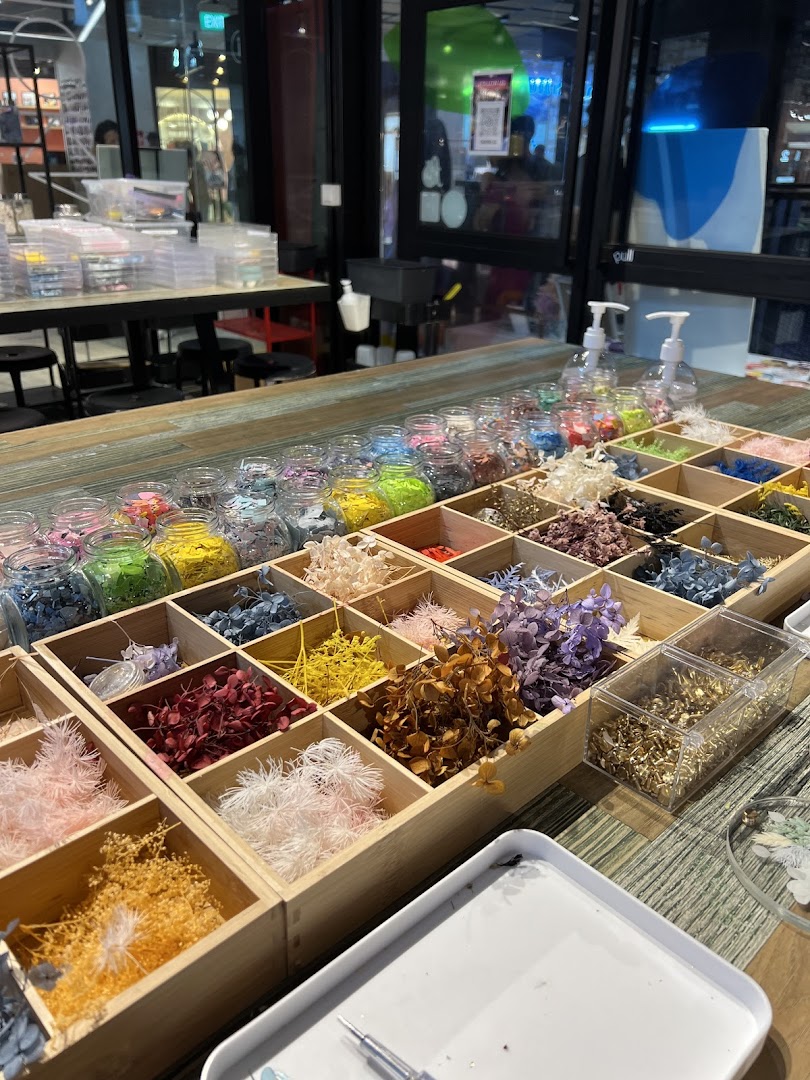 A table displaying colorful dried flowers and various craft materials for creative projects.