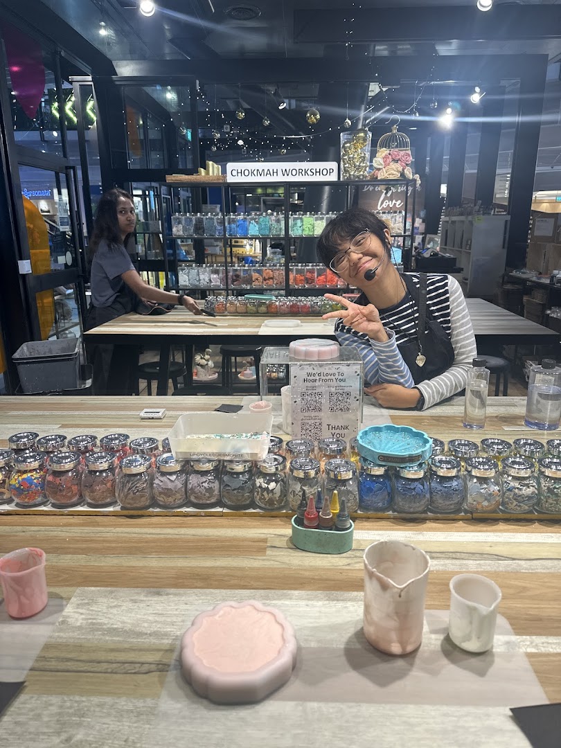 Two staff members in a vibrant Chokmah workshop, surrounded by crafting materials and projects.