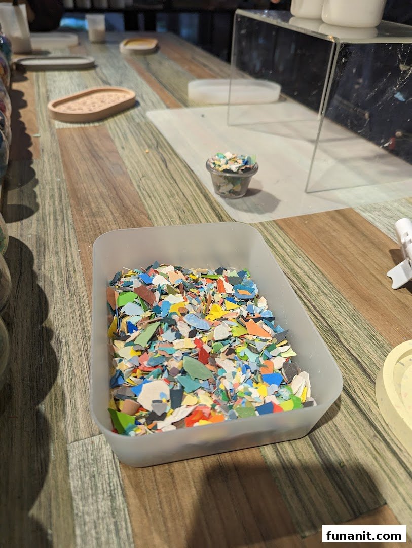 A close-up of colorful recycled material chips in a container on a wooden table, ready for crafting.