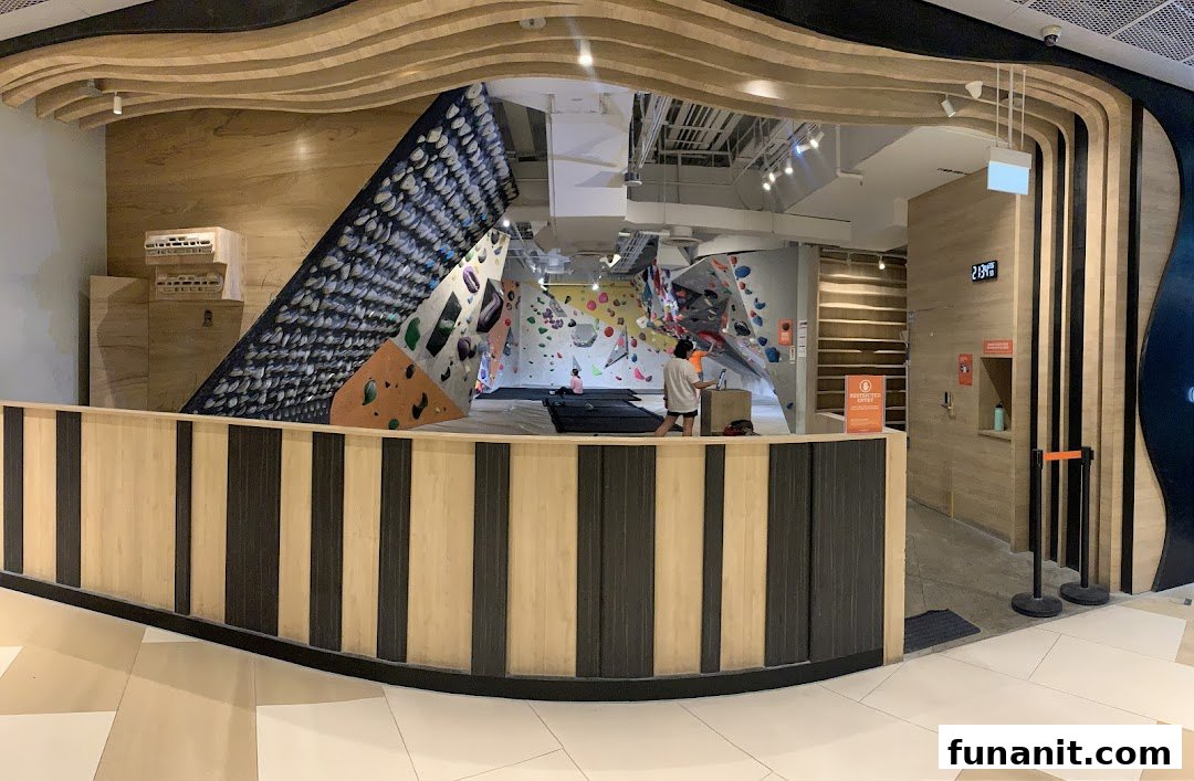 View of Climb Central Funan's entrance, showcasing bouldering walls and climbers inside.