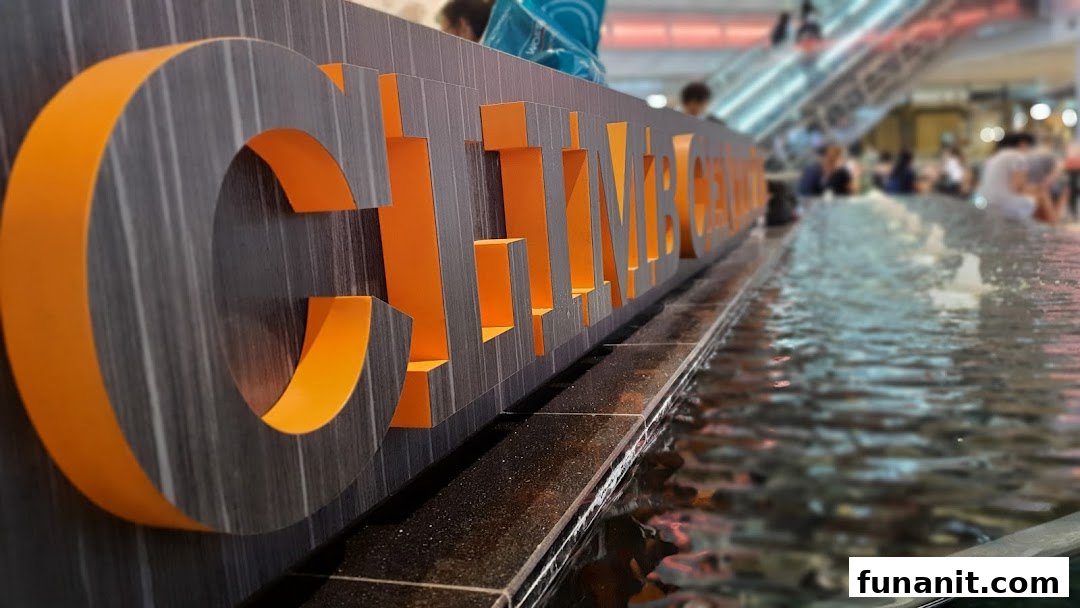 Close-up of the 'Climb Central' sign, partially submerged in a water feature within a bustling mall.