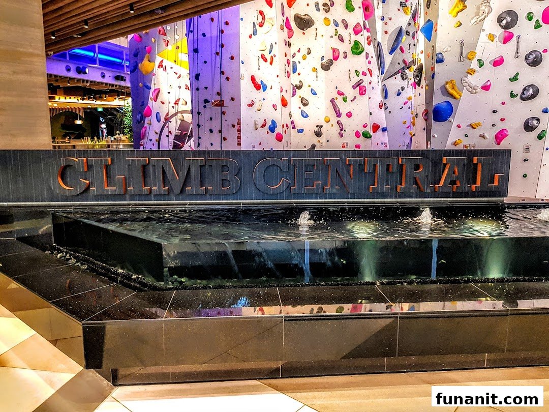 The entrance to Climb Central Funan, featuring a water display and vibrant climbing walls in the background.