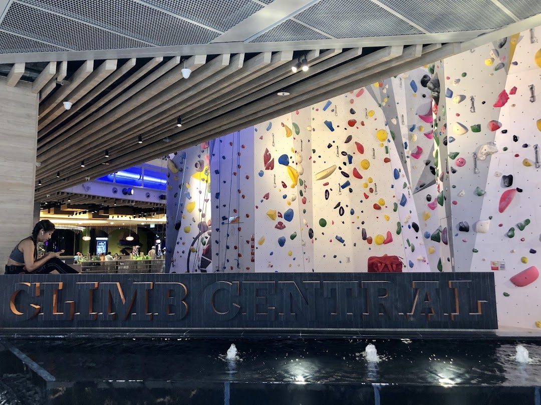 The entrance of Climb Central Funan featuring large climbing walls and a decorative water feature.
