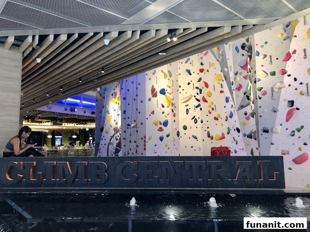 The entrance of Climb Central Funan featuring large climbing walls and a decorative water feature.