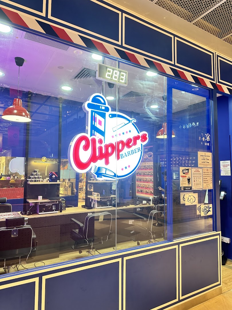 The vibrant blue storefront of Clippers Barber at Funan, showcasing its retro-inspired interior.