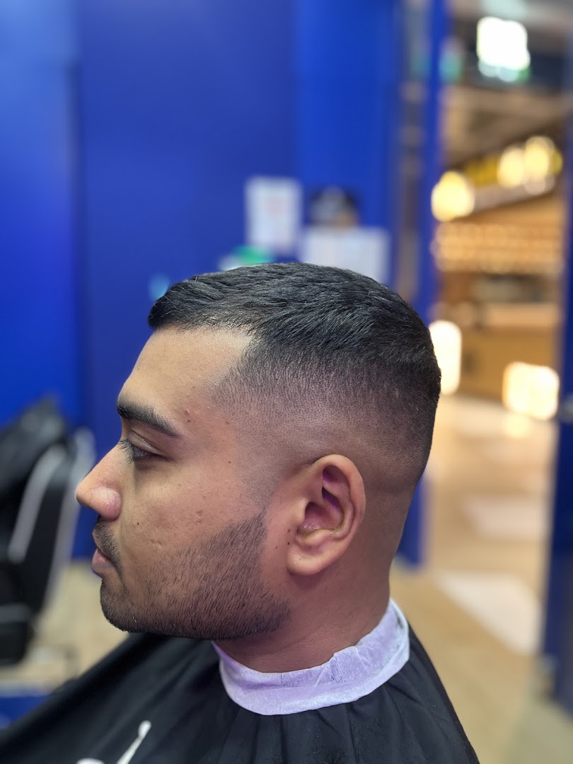A man showcasing a fresh, sharp fade haircut at Clippers Barber Funan.