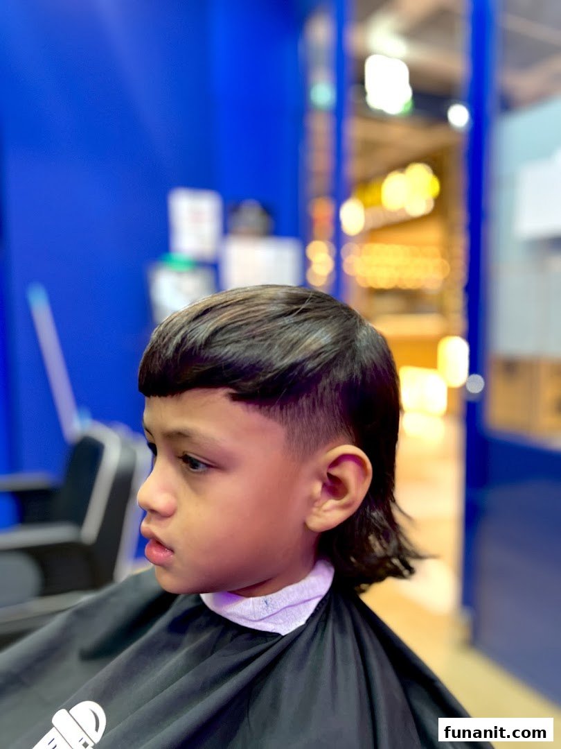 A young boy receiving a stylish haircut at Clippers Barber Funan, showcasing the shop's services.