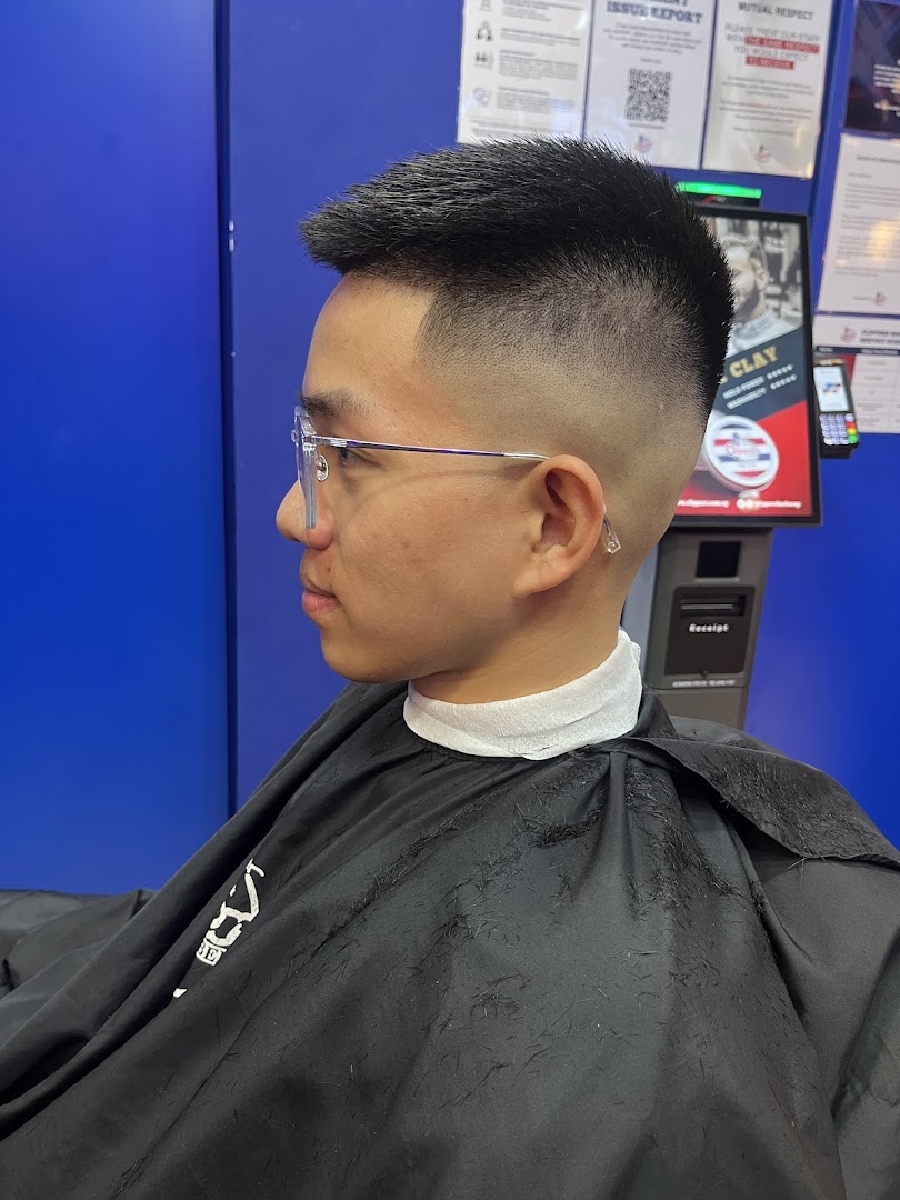 A customer showcasing a fresh fade haircut at Clippers Barber Funan, highlighting the shop's styling expertise.