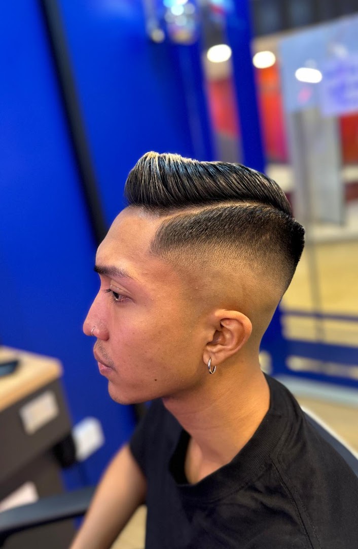 A man showcasing a fresh, stylish haircut with a modern fade and pompadour.