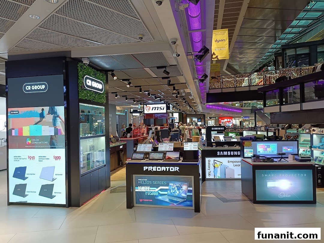 An interior view of CR GROUP, an electronics store showcasing laptops, smart projectors, and other tech products.