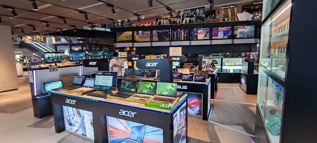 An electronics store interior showcasing a wide range of Acer and ASUS laptops and tech products.