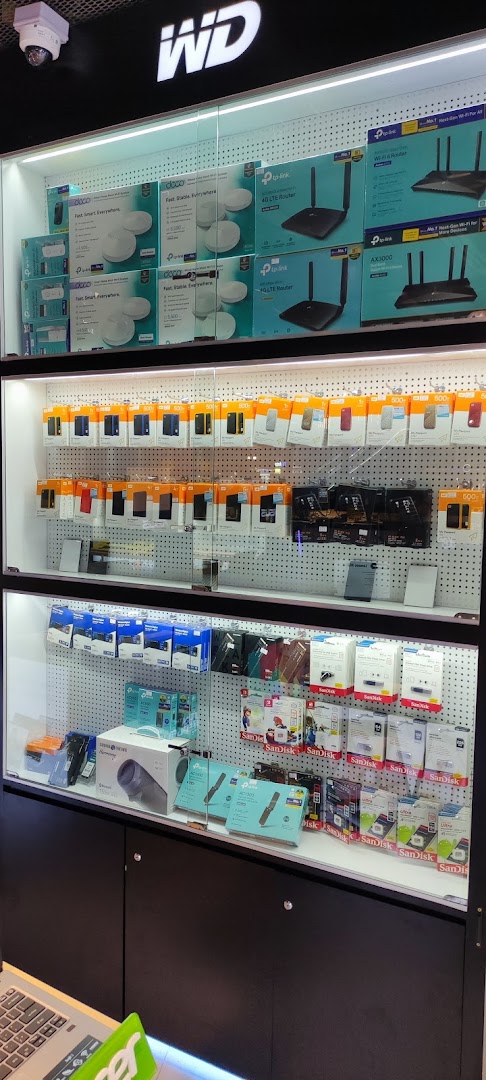 A well-lit display cabinet showcasing a variety of electronics, including routers, external hard drives, and memory cards.