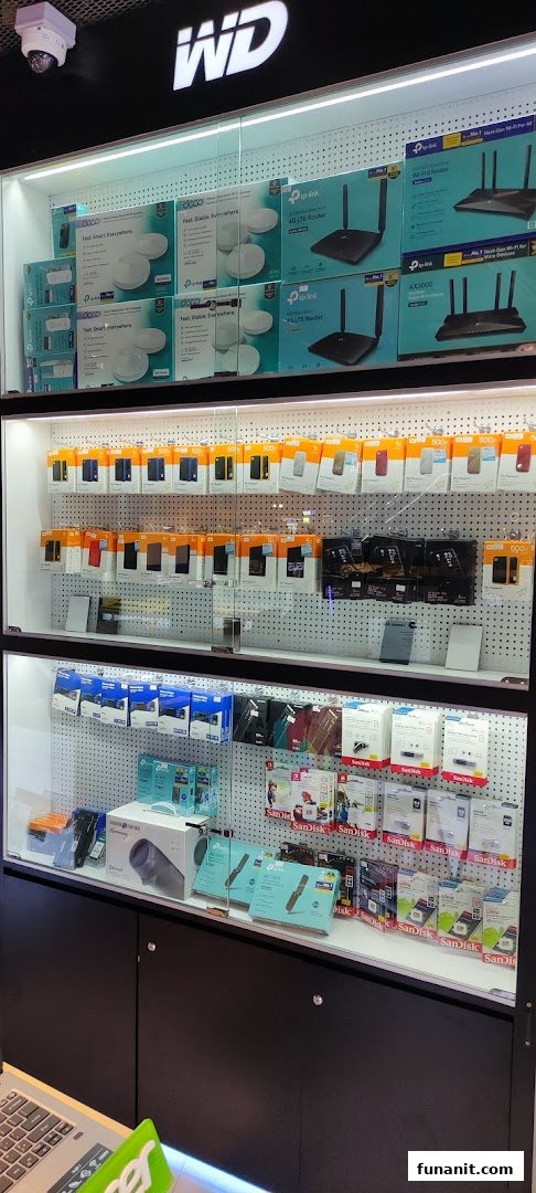 A well-lit display cabinet showcasing a variety of electronics, including routers, external hard drives, and memory cards.