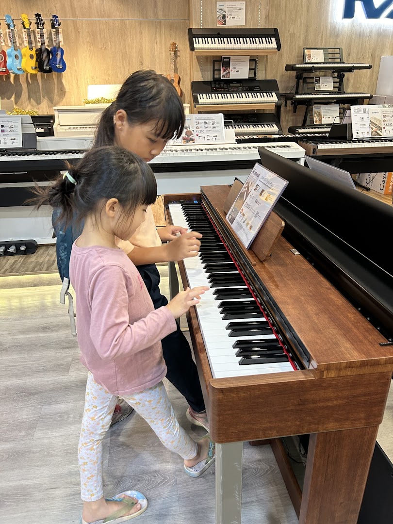 Two children are engaged in playing a digital piano within a music instrument store.