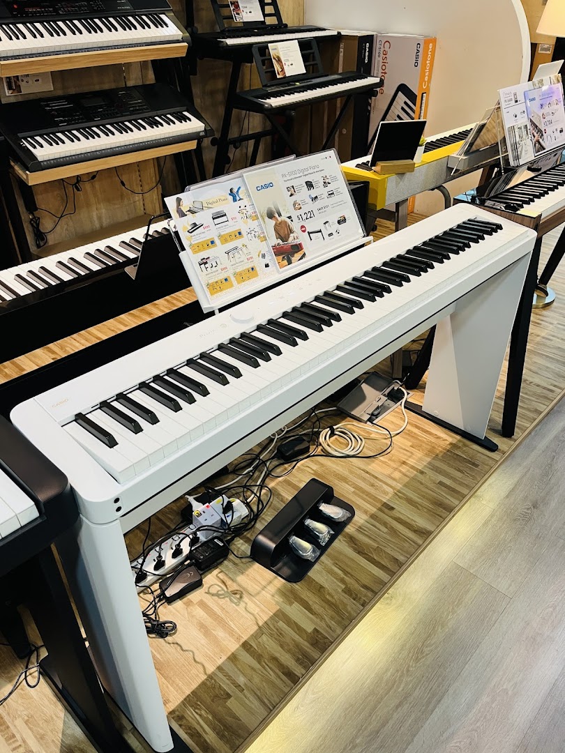 An array of digital pianos and keyboards displayed in a modern music experiential center.