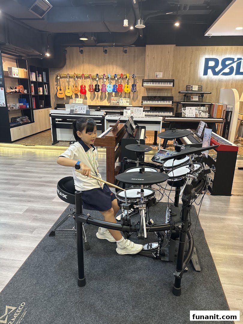 A child plays an electronic drum set inside Cristofori Music, surrounded by various musical instruments.