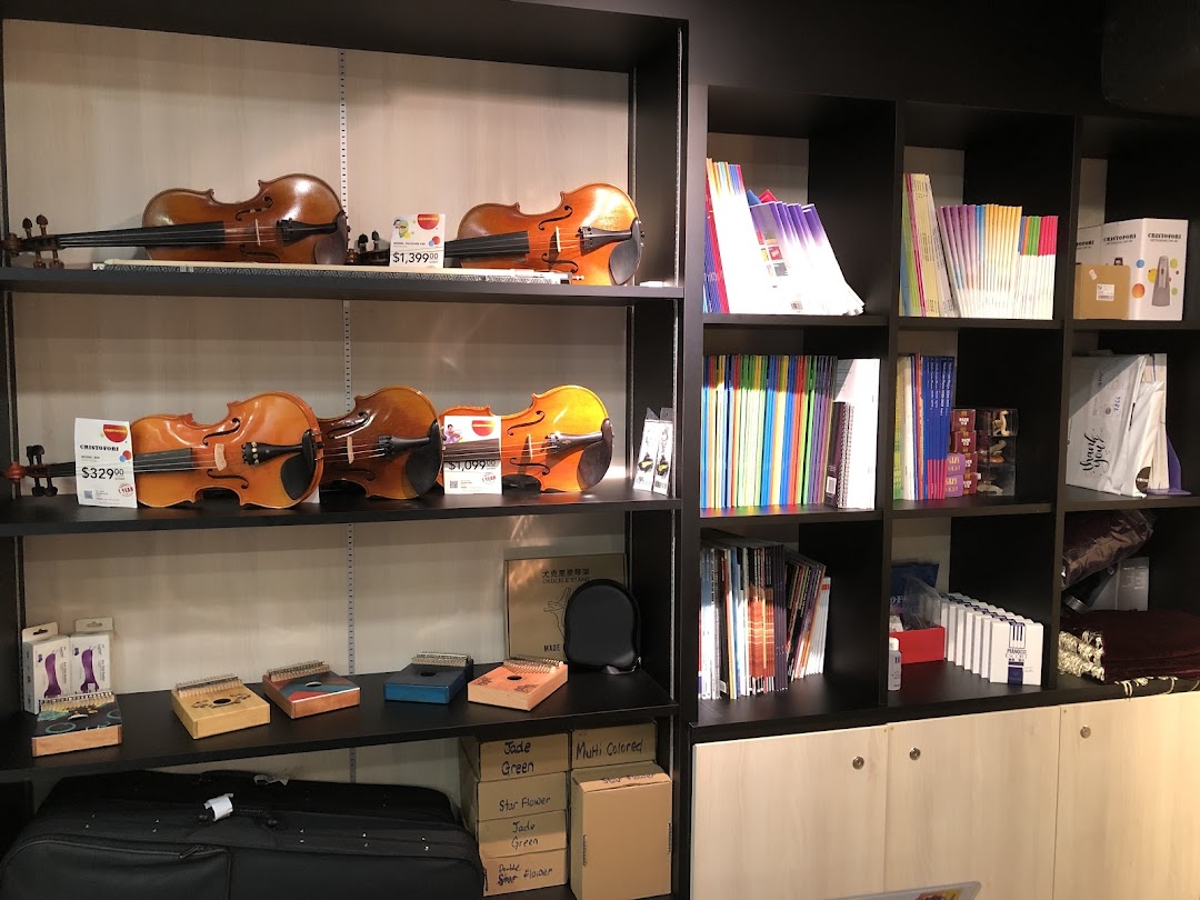 Shelves displaying violins, kalimbas, and music books in a well-stocked music store.