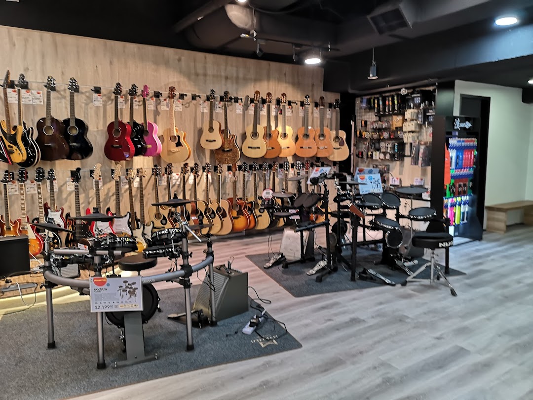 Interior of Cristofori Music Experiential Center showcasing a wide array of guitars and electronic drum sets.