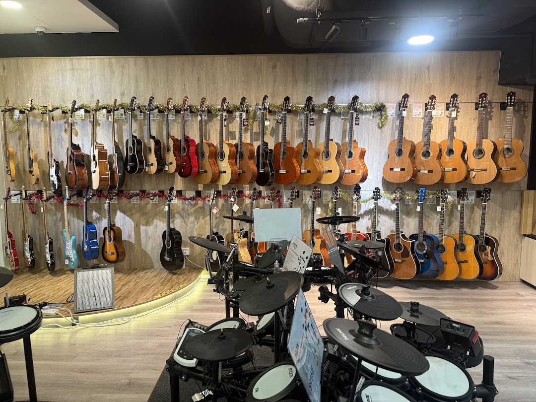An interior view of a music store showcasing a wide array of acoustic and electric guitars, alongside electronic drum sets.
