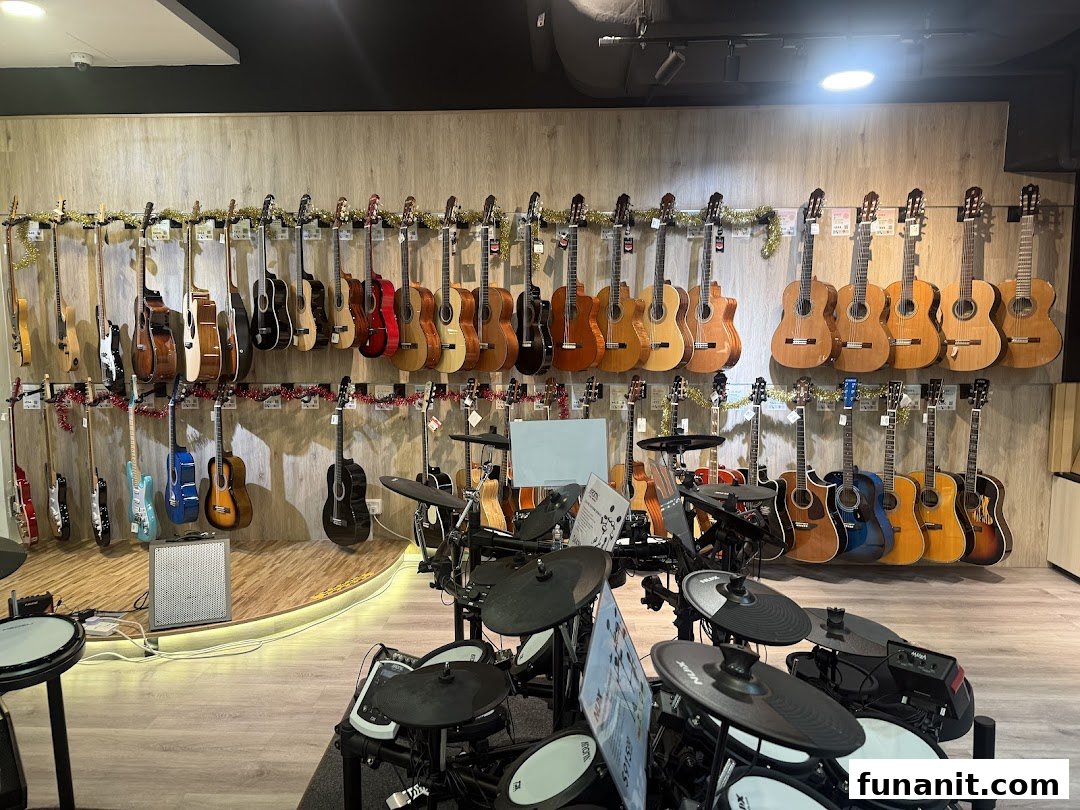 An interior view of a music store showcasing a wide array of acoustic and electric guitars, alongside electronic drum sets.